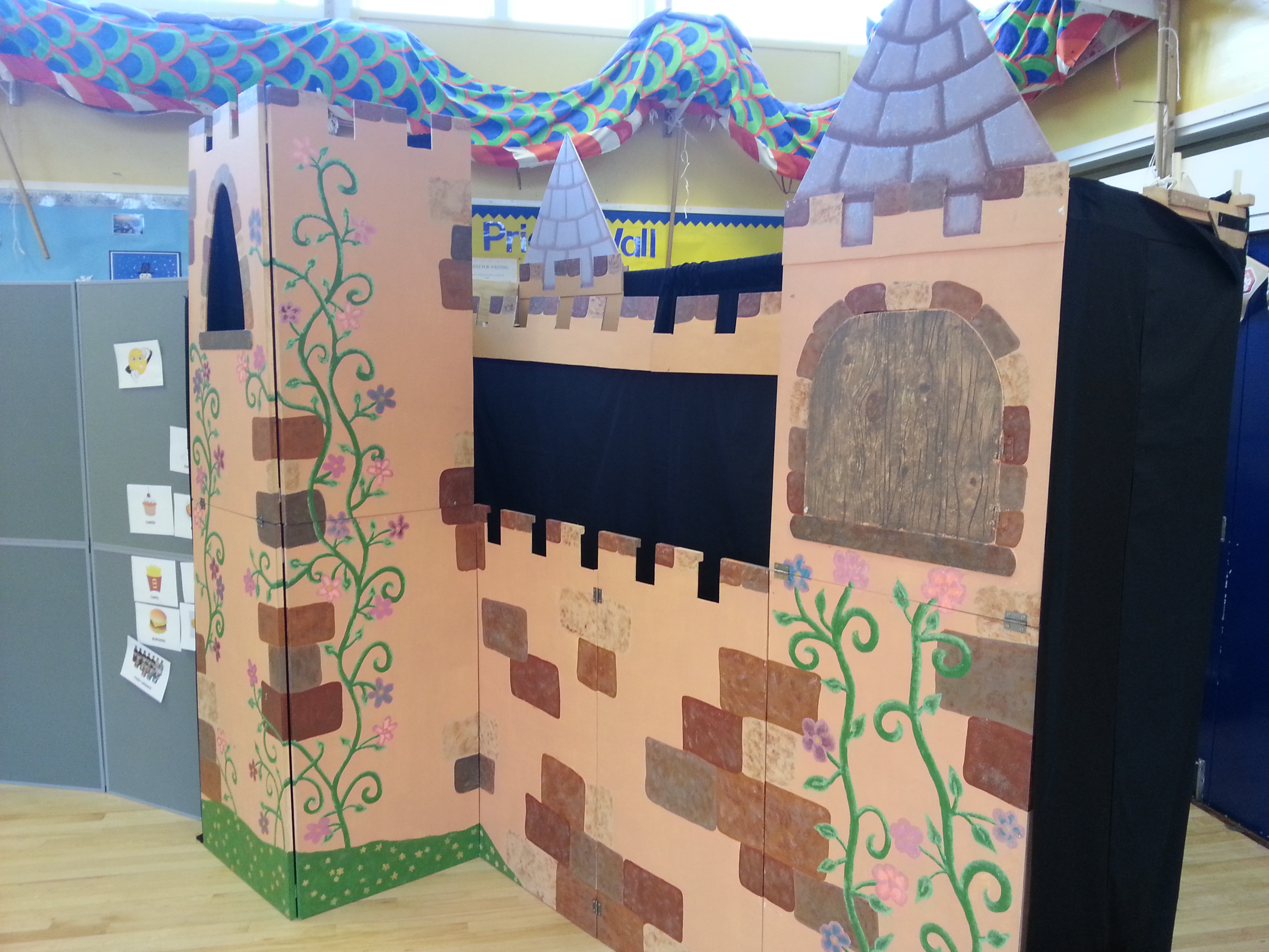 A colourful castle puppet theatre with characters performing
