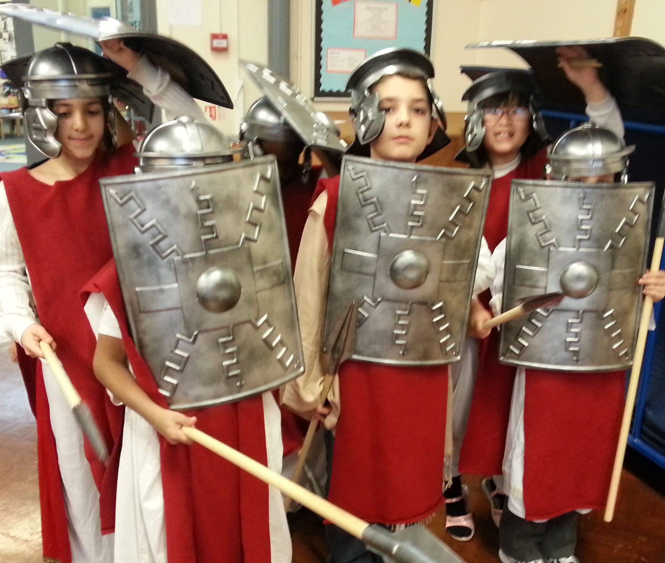 Primary school children dressed as Roman soldiers with helmets and shields