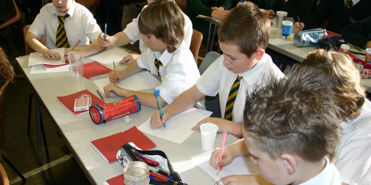 Primary pupils concentrating on a Magic Maths activity
