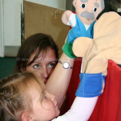 A child and adult learning to manipulate hand puppets